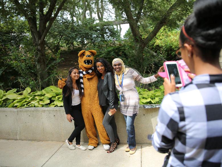 Students taking photo of friends with mascot